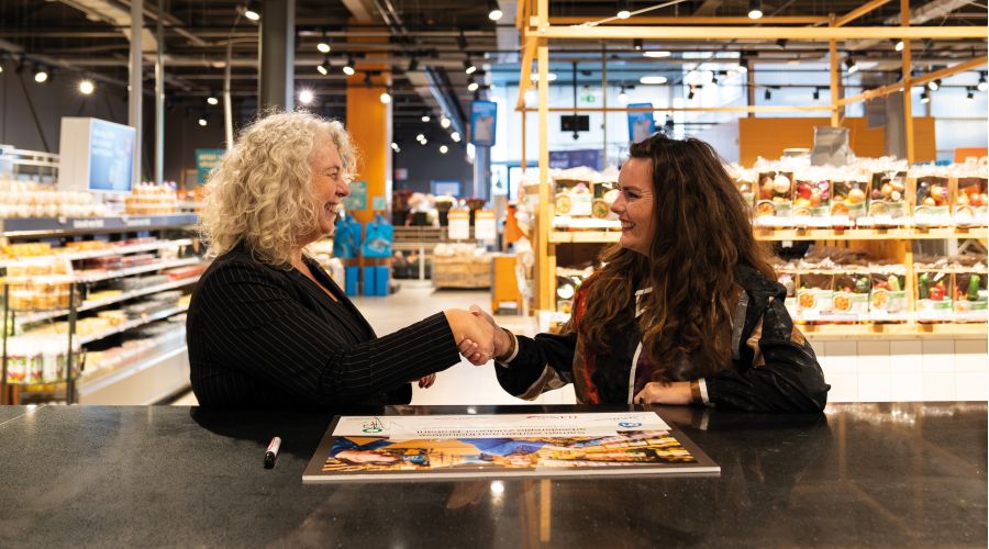 Yvonne van Hest, directeur Werken & Leren bij Ergon schudt de hand van Amanda van der Swart, Lead Inclusiviteit Albert Heijn.